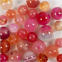 Närbild på beige och rosa agatpärlor med randiga mönster.