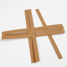 Korg flätad av stjärnstrimlor av läderpapper