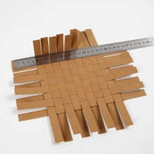 Korg flätad av stjärnstrimlor av läderpapper