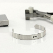 Armband av metallband präglad med text Inspiration Smyckestillverkning